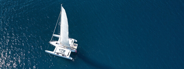 Aerial drone ultra wide photo of luxury Catamaran sailboat cruising in low speed in Mediterranean...