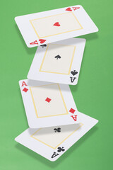 Four aces cards floating over green background