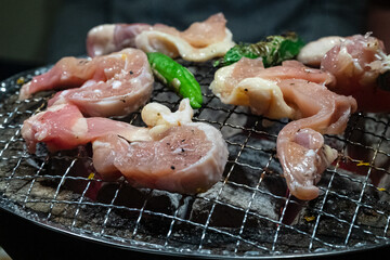 thin slides of raw pork meat on a grill