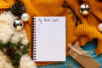 Fototapeta na wymiar Flat lay New Year decorations ans blank white spiral notebook with My wish list framed with yellow cozy winter decor, tree branches, xmas toys. Planning,wish list 2021 concept