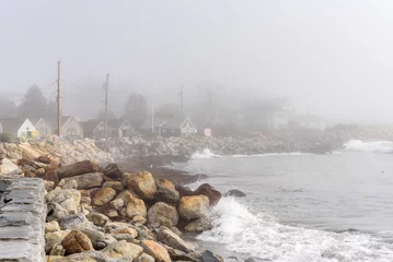 Fotobehang Rugged coast lined with wooden fisherman huts on a foggy autumn morning. New Hapshire, USA. © alpegor