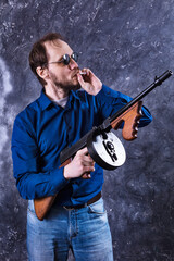 Mature man in sunglasses with tommy gun
