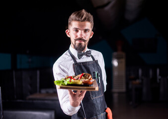 Charismatic waiter serves dish at a festive event.