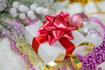 
beautiful festive surprise gift box with a red bow on a bokeh background and near the Christmas tree for new year and valentine's day