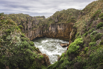 Fototapeta na wymiar Blowhole in Pancake Rocks on cloudy day. Punakaiki, South Island, New Zealand