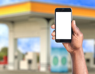 African American man paying for refueling via smartphone at gas station, closeup. Device with empty screen