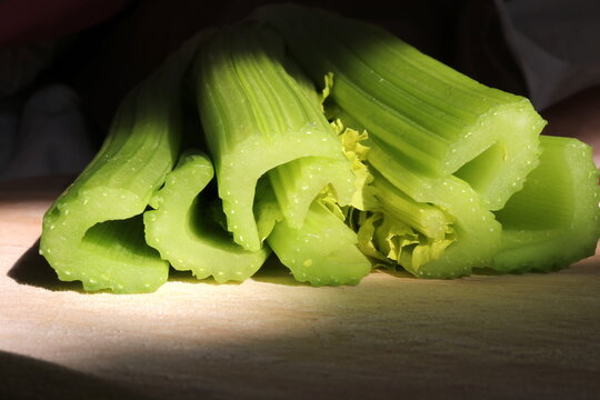 sticks of celery on wooden chopping board