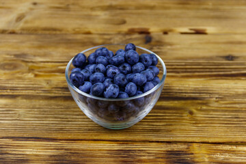 Fresh blueberry in glass bowl on a wooden table