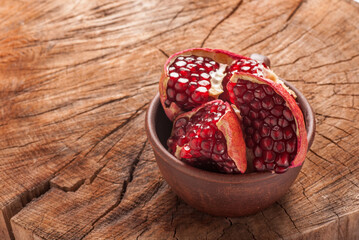 slices of pomegranate in a cured plate on an old wooden yellow table