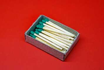 Wooden matches in cardboard box on red background