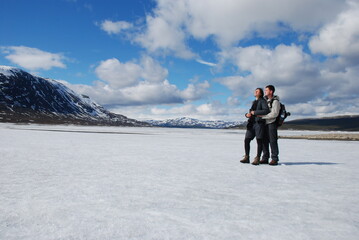 Fototapeta na wymiar A couple standing on a snowy field
