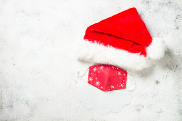 Pandemic Santa. New normal Santa. Creative composition from Santa hat, face mask and Santa beard at...