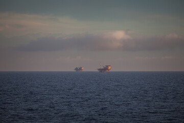 Oil platforms on the sea at dawn, Adriatic sea, Italy. Concept: extraction of fossil hydrocarbons, energy, pollution of the sea, global warming, oil company