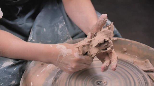 Master-ceramist creates a clay pot on a potter's wheel. Hands of potter close up. Ancient craft and pottery handmade work