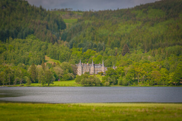 Fototapeta na wymiar Tilt shift effect of ancient manor of Mor Trossachs, facing Loch Achray, Scotland. Concept: travel to Scotland, typical landscapes of Scotland