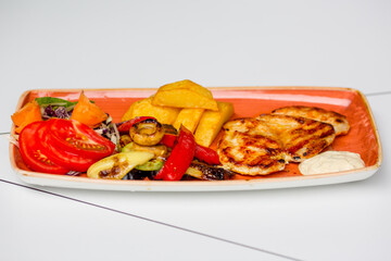 Grilled chicken with a side dishes of vegetables.