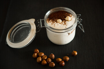 Dessert - Panna cotta with hazelnuts in a glass on a black background up close. Healthy delicious...