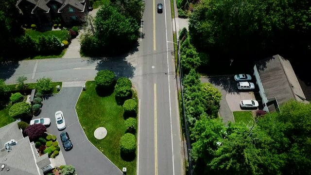 Bird's Eye Camera Tilt View of Moving Cars on a Suburban Country Road