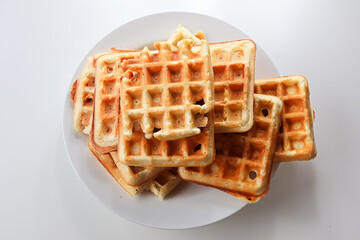 Plain waffles on a while plate against a white background