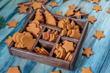 Collection of various gingerbread cookies in a box on wooden background