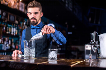 Focused bartender demonstrates his professional skills in the nightclub