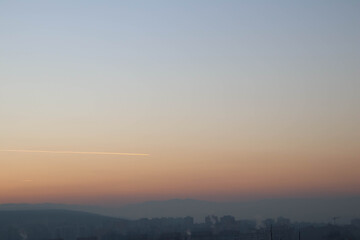 Bright sky over city and mountains