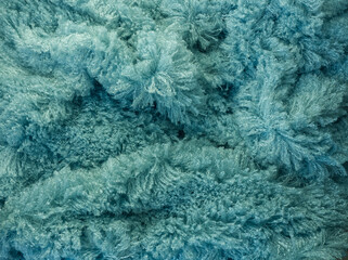 Fluffy fur fabric macro texture for background or template. Fuzzy fabric for winter day. Tide water green fur, winter fabric textile.