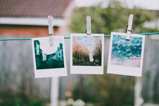 photos hanging on clothesline photo frame blank photography picture clothesline photograph clothespin sky polaroid rope hanging film empty instant album old nature line photos paper white landscape