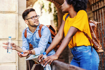 Young multiracial couple standing outdoors and chatting. Tourism concept.