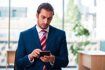 Young handsome employee working in the office