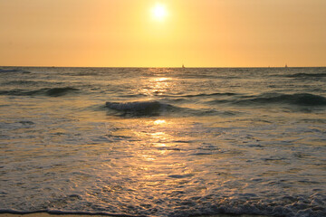 Obraz premium orange sky sunset over the sea waves 