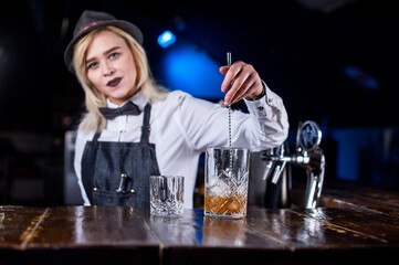 Girl barman concocts a cocktail in the pothouse © Mr. Prof