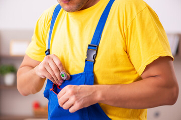 Young male carpenter stealing jewelry at home