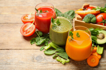 Delicious vegetable juices and fresh ingredients on wooden table