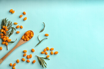 Fresh ripe sea buckthorn on light blue background, flat lay. Space for text