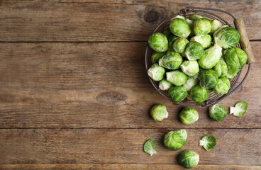 Fresh Brussels sprouts on wooden table, flat lay. Space for text