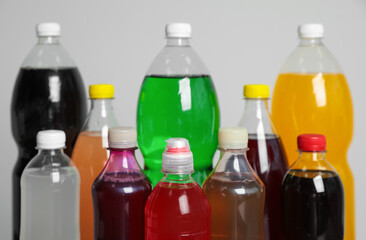 Bottles of soft drinks on grey background, closeup
