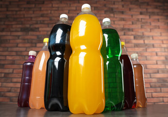 Bottles of soft drinks on table against brick wall, low angle view