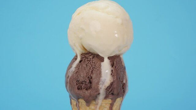 
Closeup Zoom out, Time Lapse Vanilla ice cream on top Chocolate ice cream cone isolated on blue background.