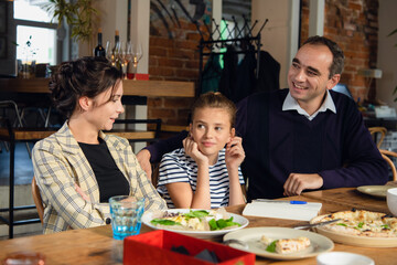 Young parents helping their daughter to compose a letter to somebody.