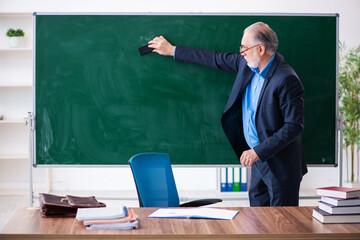 Old male math teacher in the classroom