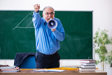 Angry aged male math teacher holding megaphone