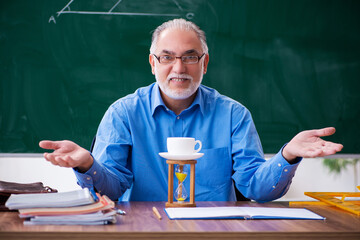 Old male math teacher in time management concept