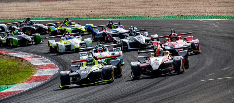 Many racing single seater cars aligned in circuit during formation lap