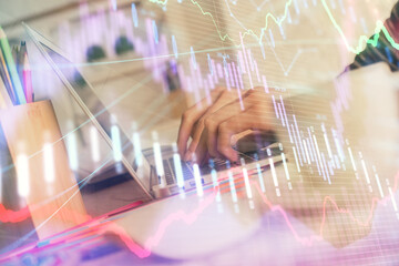 Double exposure of woman hands typing on computer and forex chart hologram drawing. Stock market invest concept.