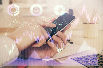 Fototapeta premium Double exposure of man's hands holding and using a digital device and forex graph drawing. Financial market concept.