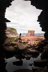 Girl going outside a cave at the basque coast.	
