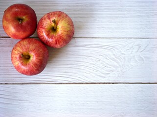 Red apples on white wooden background