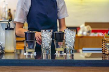 Barista making milk coffee with dripping filter in Vietnamese coffeeshop