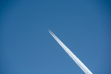 寒い冬の朝の青空と飛行機雲